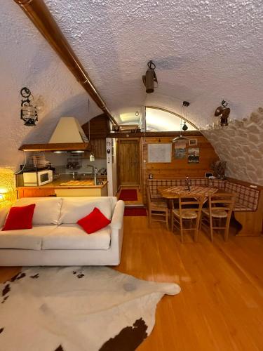 a living room with a white couch and a table at Rifugio del vicolo in Lucoli Alto