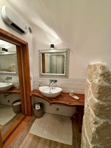 a bathroom with two sinks and a mirror at Rifugio del vicolo in Lucoli Alto