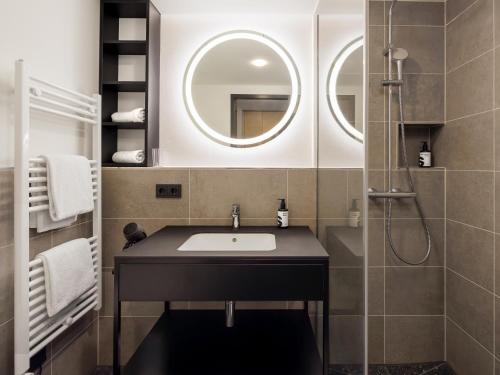 a bathroom with a sink and a mirror at smartments Bielefeld Hauptbahnhof in Bielefeld
