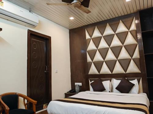 a bedroom with a large bed with a wooden headboard at Hotel Sudarshan in Haridwār