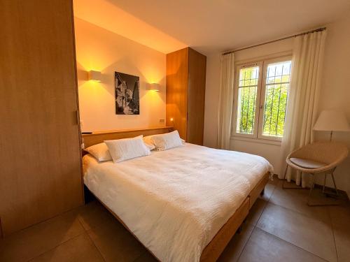 a bedroom with a large bed and a window at Clos des Oliviers Grimaud - Meublé de Tourisme in Grimaud