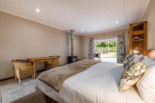a bedroom with a large bed and a desk at Misty Mountain in Sabie
