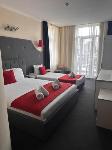a hotel room with two beds with towels on them at Cattleya Boutique Hotel in Ruse