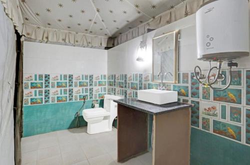a bathroom with a toilet and a sink at Tiger Resort Boho in Khilchipur
