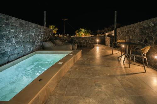 a swimming pool in the middle of a patio at night at Santorini Cave Luxury Suites in Fira