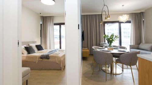 a room with a bed and a table with chairs at Sol Marina 231 in Wiślinka