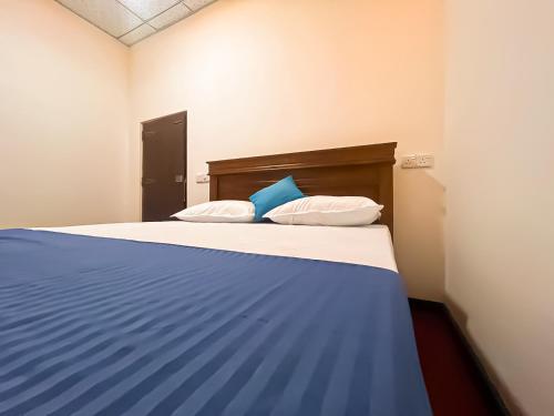 a bedroom with a blue and white bed with two pillows at Dan Sewana in Nochchiyagama