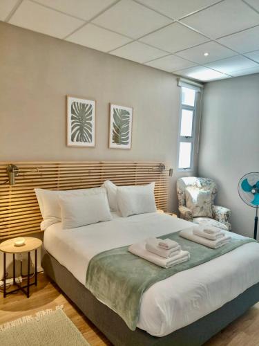 a bedroom with a large bed with towels on it at The Botanic High Gold in Paarl