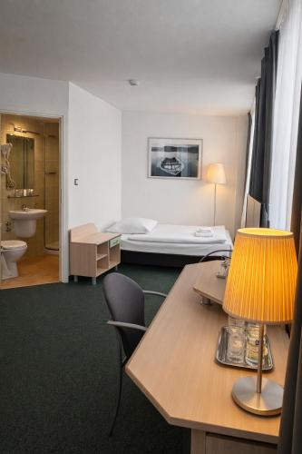 a hotel room with a bed and a table with a lamp at Hotel Logos in Warsaw