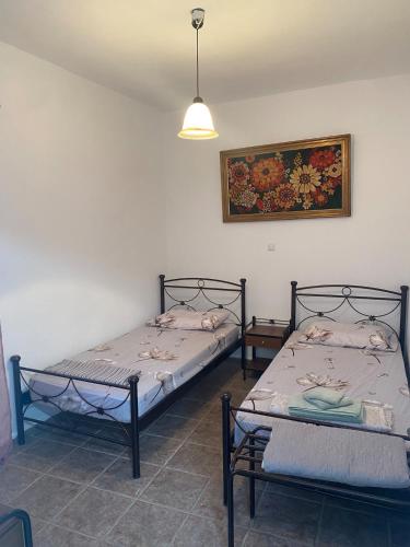 two beds in a room with a picture on the wall at Mimi's House 2 in Véssa