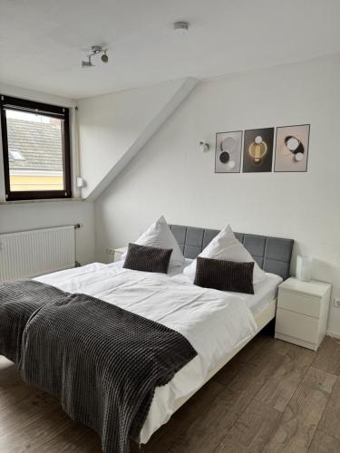 a bedroom with a large bed with white sheets at Oberkasseler Hof Bonn in Bonn
