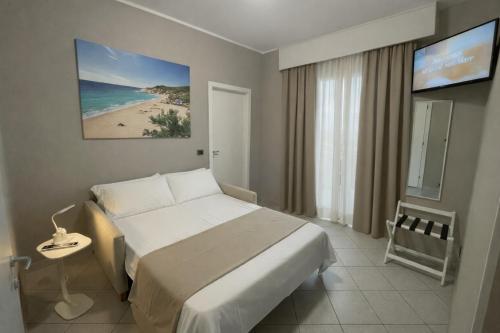 a bedroom with a bed and a view of a beach at Hotel SoleMare in Diano Marina
