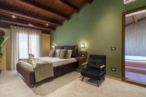 a bedroom with a large bed and a chair at La Piazzetta Sea Rooms in Balestrate