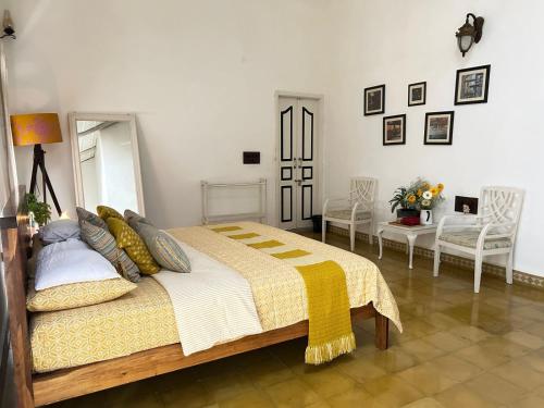 a bedroom with a large bed and two chairs at Crepe Ginger Home Stays in Hariharpur