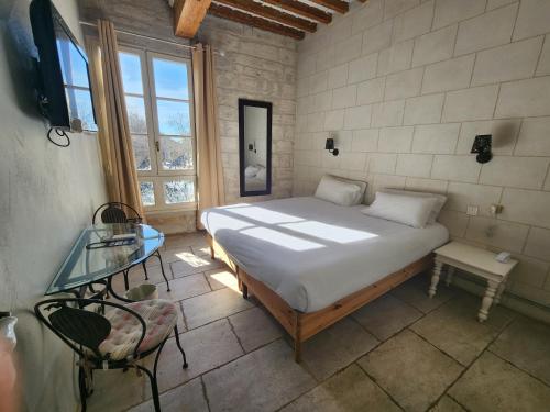 a bedroom with a bed and a glass table at Hôtel du Palais des Papes in Avignon