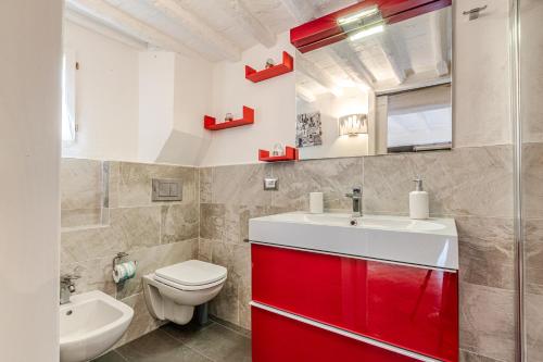 a bathroom with a red cabinet and a toilet at Charming Mezzanino in Siena