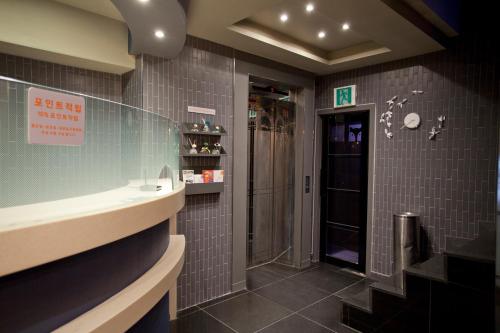 uma casa de banho com uma cabina de duche ao nível do chão e um lavatório. em MW Hotel em Seul