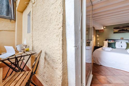 a bedroom with a bed and a balcony with a table at Charming Mezzanino in Siena