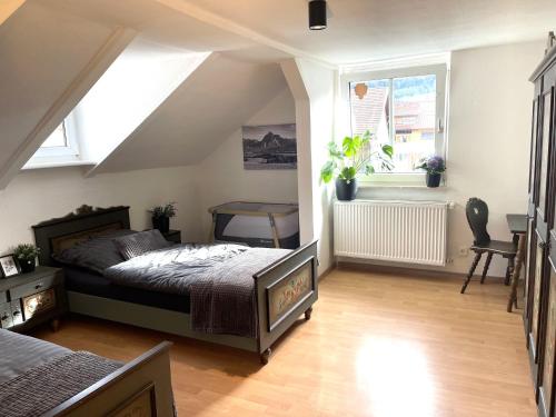 a bedroom with a bed and a desk and two windows at Ferienhaus Ferienwohnung CasaBergZeit mit Königscard im Allgäu, Pfronten, Füssen in Pfronten