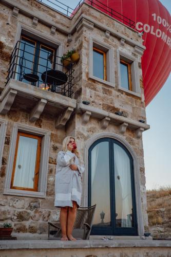 a woman standing in front of a building at Azure Cave Suites - Cappadocia in Göreme