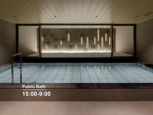 a room with a swimming pool with a glass wall at Mitsui Garden Hotel Sapporo in Sapporo