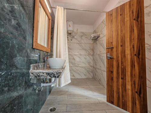 a bathroom with a sink and a shower at Om Homestay in Rishīkesh