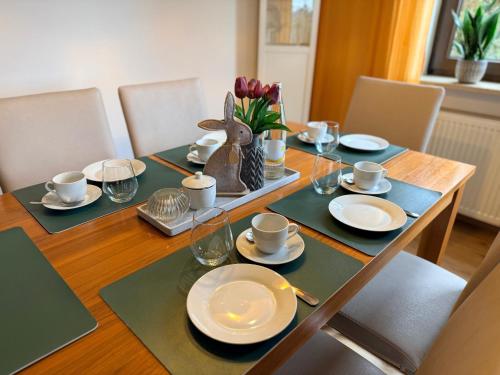 a dining room table with plates and cups on it at Casa Valentini in Zapfendorf
