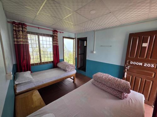a small room with two beds and a window at Hotel mardi station and restaurent in Astam