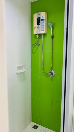 a green bathroom with a shower with a green wall at สุขุมวิท101 By KT in Amphoe Phra Khanong