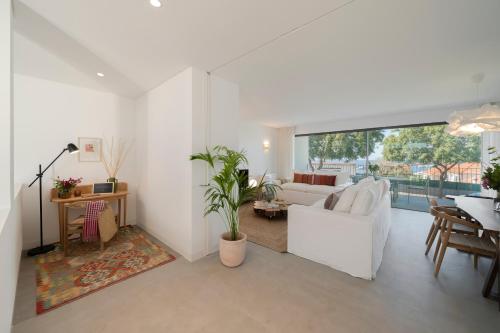 a living room with a white couch and a table at CASA DO MIRADOURO 7 by Heart of Funchal in Funchal