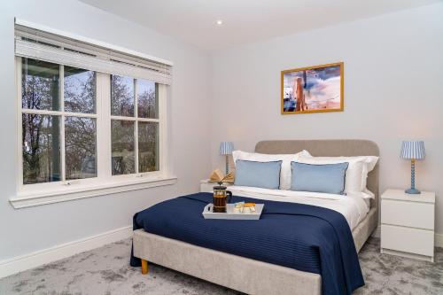 a bedroom with a bed and two windows at The Gleneagles Hideaway - Luxury 3 Bed With Complimentary Access to Onsite Leisure Facilities in Gleneagles Station