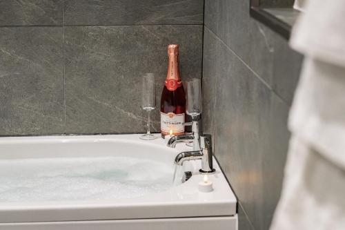 a bottle of wine sitting on top of a bath tub at The Gleneagles Hideaway - Luxury 3 Bed With Complimentary Access to Onsite Leisure Facilities in Gleneagles Station
