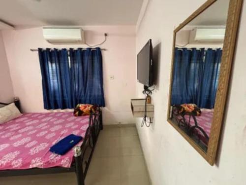 a small room with a bed and a mirror at Via Ashiyana Inn in Kolkata