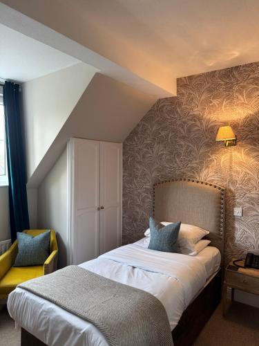 una stanza d'albergo con un letto e una sedia di Tower Hotel a Lincoln