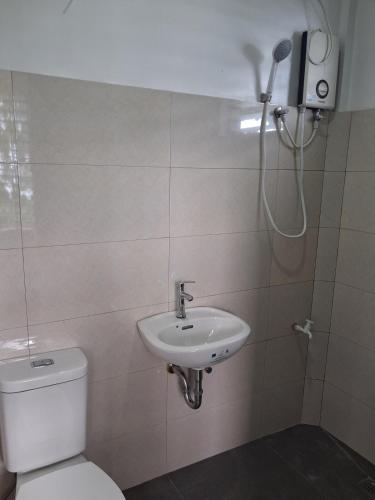 a bathroom with a toilet and a sink and a shower at el balcon camiguin in Mambajao