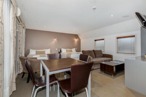 a living room with a table and a couch at Seymours On Lydiard in Ballarat