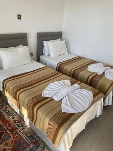 two beds sitting next to each other in a room at Hotel Hisarlık in Halileli