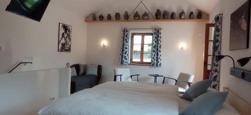 a bedroom with a bed and a chair and a window at Wohnen beim Keramiker in Kolbermoor