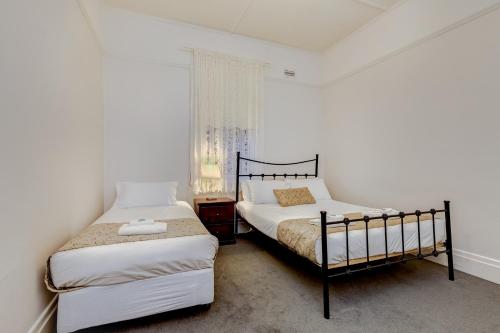 a bedroom with two beds and a window at Seymours On Lydiard in Ballarat