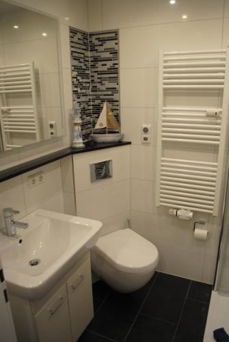 a bathroom with a white toilet and a sink at Terrassenhaus Penthouse-Wohnung 93 in Cuxhaven