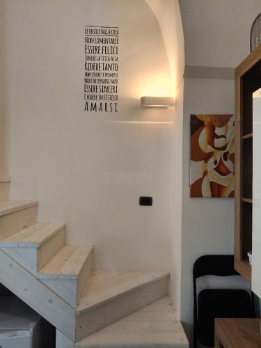 a staircase in a room with a sign on the wall at La casa della nonna by LoveSud in Castrignano del Capo