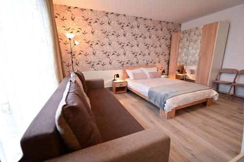 a bedroom with a bed and a couch at FLH - Binder Lake View with AC in Sibiu