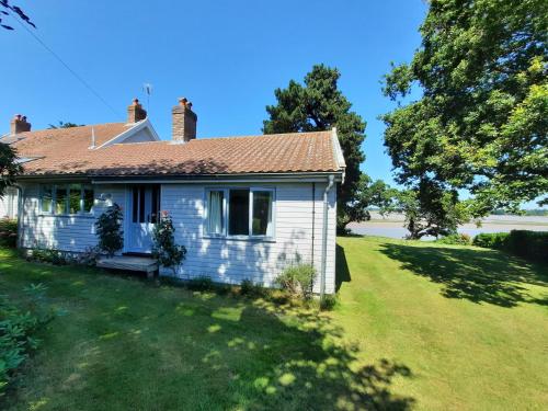 an old white house with a grass yard at River View - Stunning estuary views in Aldeburgh