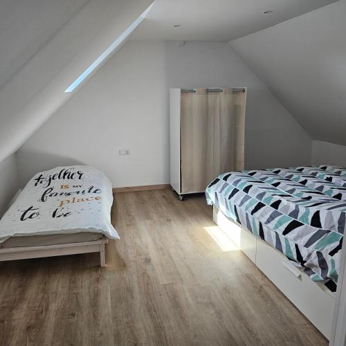 a bedroom with a bed and a wooden floor at Hébergement Cosy in Bourg-et-Comin