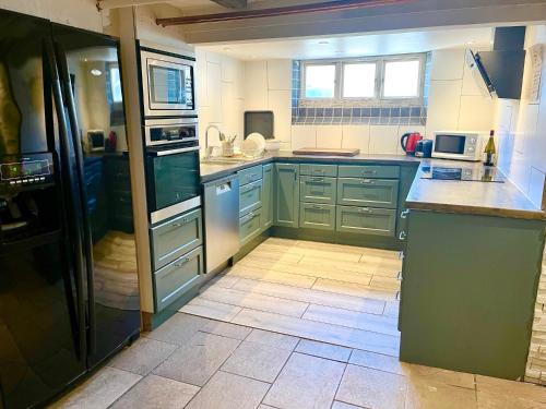 a kitchen with blue cabinets and a tile floor at Hotell Trasten Tylösand in Tylösand