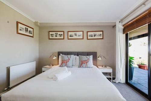 a bedroom with a large white bed with two lamps at 10 Kanangra Crescent - Entire in Jindabyne