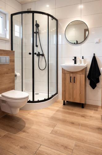 a bathroom with a shower and a toilet and a sink at PoProstuDomki in Niechorze