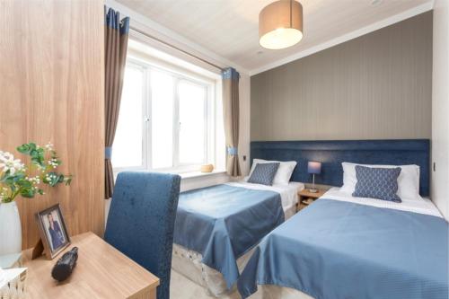 a hotel room with two beds and a window at Lyndale Lodge in Pulrossie