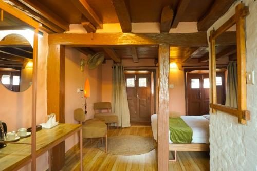 a hotel room with a bed and a mirror at Bandipur Bazar Ghar in Bandipur