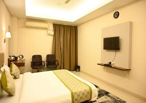 a hotel room with a bed and a flat screen tv at TTAMAASHA INNN in Chinhat